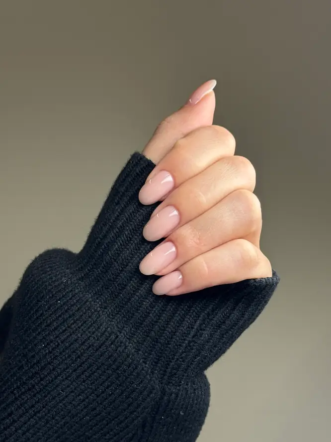 Soft blush-nude gel on almond nails — barely-there finish, client manicure.
