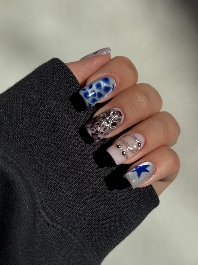 Maximalist nail art — blue leopard, chrome florals and star accents, client work.