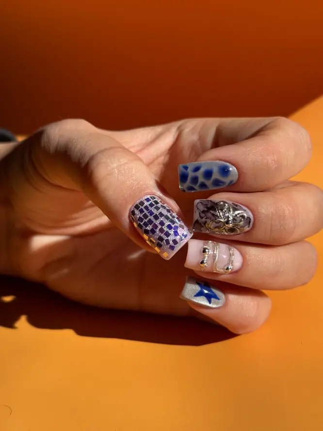 Maximalist nail art — mosaic glitter, blue leopard print, star and 3D silver, client work.