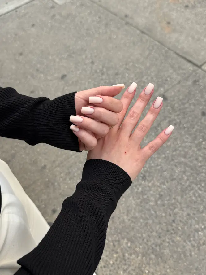 Milky-white gel on square nails — casual New York street shot, client work.