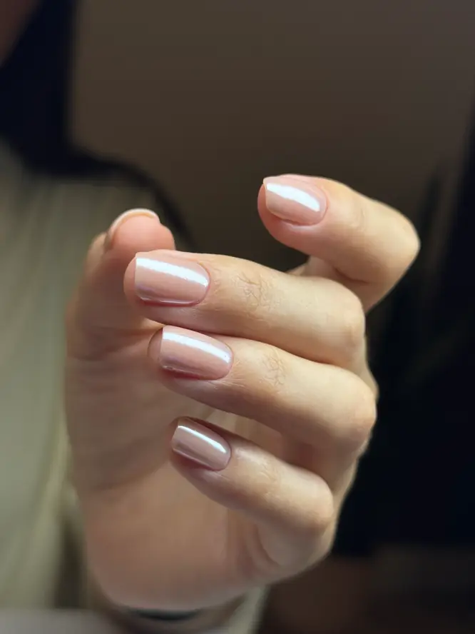Pearl-shimmer nude gel on short square nails in warm evening light — client work.