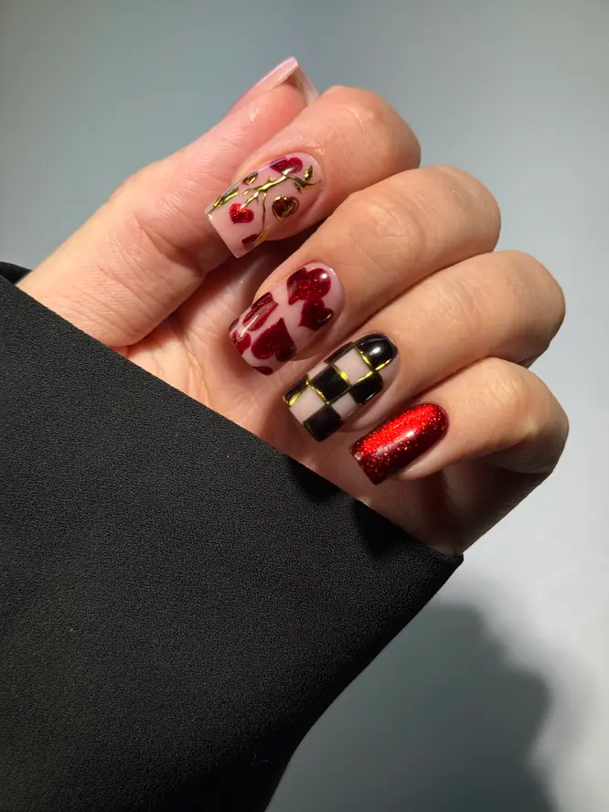 Valentine mix-and-match nail art — hand-painted hearts, checkerboard and glitter, client work.